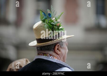 Bucarest, Romania - 5 marzo 2020: Dettagli con il tradizionale cappello rumeno di paglia di un uomo anziano, adornato con fiori, foglie e piume di pavone Foto Stock