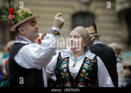 Bucarest, Romania - 5 marzo 2020: Donne e uomini anziani, vestiti con abiti tradizionali rumeni, ballano in un festival. Foto Stock