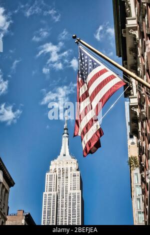 L'iconico Empire state Building è visto con una bandiera americana sulla Fifth Avenue, New York City, USA Foto Stock