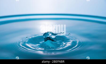 Primo piano con spruzzi d'acqua. Corona di acqua blu. Goccia d'acqua. Schizzi congelati. Foto Stock