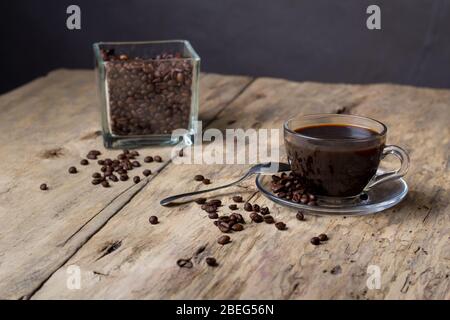 Caffè in una tazza di vetro trasparente su un tavolo di legno Foto Stock