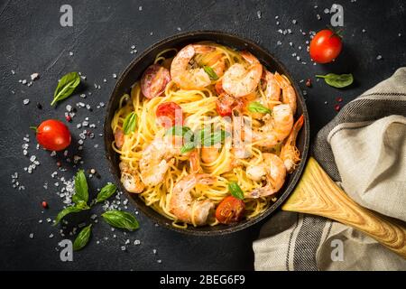 Pasta di pesce con gamberi su tavola nera. Foto Stock