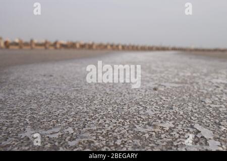 Fondo sabbioso di un serbatoio essiccato con crepe e cristalli di sale. Foto Stock