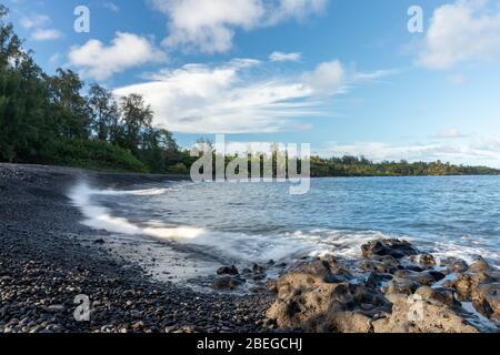 La spiaggia di sabbia nera di Kainalimu Bay a Hana, Hawaii Foto Stock