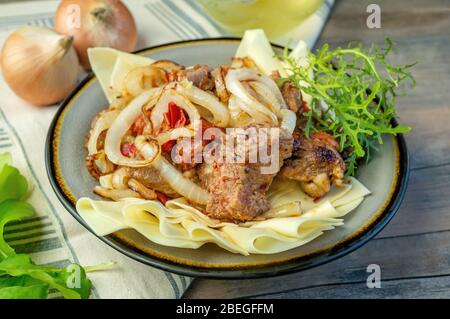 Piatto di Beshbarak: Tagliatelle con agnello e cipolla primo piano su un piatto sul tavolo. Foto Stock