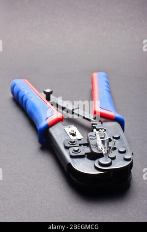 Pinza a crimpare per cavi di rete isolata su sfondo bianco Foto Stock