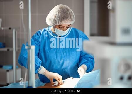 Le fotografie dei medici in maschere protettive e camici da laboratorio lavorano intensivamente in terapia intensiva. Reparto rianimazione, salvavita, polmonite, Covid Foto Stock