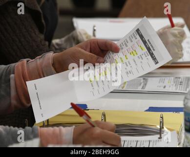 Racine, Wisconsin, Stati Uniti. 13 Aprile 2020. Un foglio di controllo di scrutinio assentato è esaminato come scrutinio gettato a Racine, Wisconsin durante il controverso aprile 7 le elezioni presidenziali primarie e statali del Wisconsin sono tabulate Lunedi 13 aprile 2020. Ogni busta di urna è stata aperta e controllata per verificare la conformità con le leggi elettorali prima di essere alimentata in una macchina di tabulazione. La città aveva solo opzioni di voto per scrutinio di posta assentee e drive-up; non c'era il voto di persona consentito. Le elezioni si sono svolte secondo le direttive di sentenze sia del Wisconsin che degli Stati Uniti. I risultati dovevano essere Foto Stock