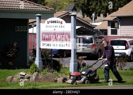 Portland, Stati Uniti. 13 Aprile 2020. Un lavoratore si aromica il prato della Sanità presso la struttura di cura intermedia di Foster Creek a Portland, Ore., il 13 aprile 2020. Dieci residenti della casa di cura sono morti secondo quanto riferito dal romanzo coronavirus, che rappresenta quasi un quinto dei decessi totali dello stato. (Foto di Alex Milan Tracy/Sipa USA) Credit: Sipa USA/Alamy Live News Foto Stock