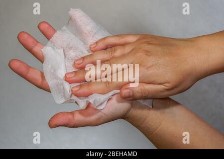 Pulizia efficace delle mani con salviette antisettiche igienizzanti a base di alcool. La femmina contiene salviette morbide e preumidificate e la sfrega come disinfettante Foto Stock