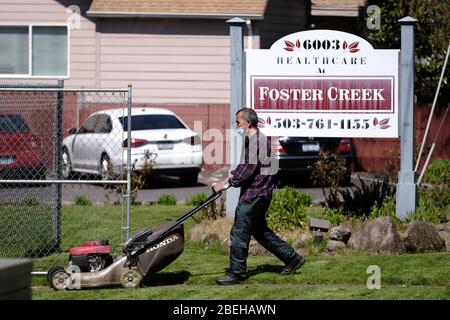 Portland, Stati Uniti. 13 Aprile 2020. Un lavoratore si aromica il prato della Sanità presso la struttura di cura intermedia di Foster Creek a Portland, Ore., il 13 aprile 2020. Dieci residenti della casa di cura sono morti secondo quanto riferito dal romanzo coronavirus, che rappresenta quasi un quinto dei decessi totali dello stato. (Foto di Alex Milan Tracy/Sipa USA) Credit: Sipa USA/Alamy Live News Foto Stock