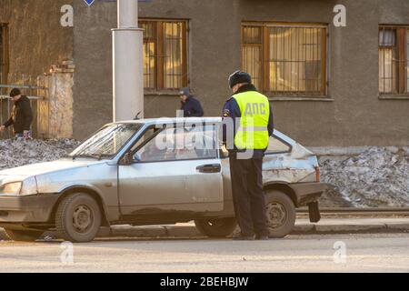 Kemerovo, Russia - 2019, l'ufficiale della polizia stradale ha fermato una vecchia auto stropicciata e graffiata per il controllo dei documenti Foto Stock