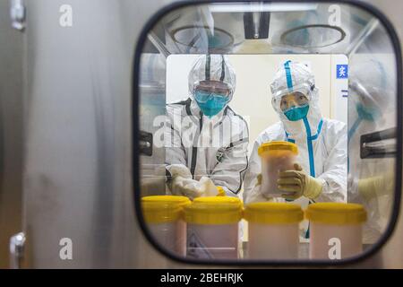 (200414) -- PECHINO, 14 aprile 2020 (Xinhua) -- i membri del personale ricevono il nuovo ceppo di coronavirus trasportato dal Centro Provinciale di Zhejiang per il controllo e la prevenzione delle malattie, presso un laboratorio del Centro Cinese per il controllo e la prevenzione delle malattie, a Pechino, capitale della Cina, 25 febbraio 2020. La Cina ha approvato due vaccini inattivati COVID-19 per gli studi clinici, secondo il meccanismo comune di prevenzione e controllo del Consiglio di Stato contro il coronavirus martedì. I due candidati al vaccino sono sviluppati dal Wuhan Institute of Biological Products sotto la China National Pharmaceu Foto Stock