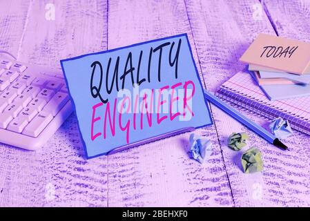 Testo Di Scrittura Quality Engineer. La foto concettuale garantisce la qualità complessiva di Un Notpaper di prodotti analisisufacturati che si trova sul filo tampone tra di loro Foto Stock