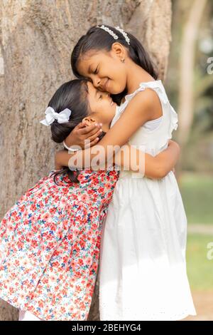 Piccole sorelle teneri che si abbracciano e mostrano il loro vero amore Foto Stock