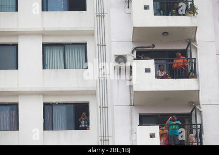 Bhaktapur, Nepal. 14 Aprile 2020. I residenti guardano fuori dalle loro finestre del balcone agli appartamenti di Sun City mentre il personale della polizia sigilla la zona dopo che tre membri di una famiglia che vi abitavano hanno provato positivo per la nuova malattia di coronavirus in test rapidi in Bhaktapur, Nepal, Martedì 14 aprile 2020. Credit: Skanda Gautam/ZUMA Wire/Alamy Live News Foto Stock