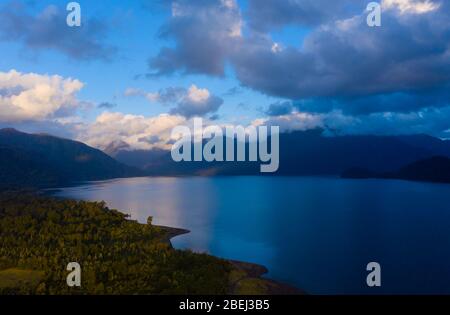 Vista aerea del lago Chapo circondata da montagne coperte di foresta nativa Foto Stock