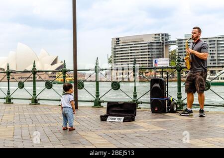 Un autobus di strada sassofono attira l'attenzione da un bambino Foto Stock