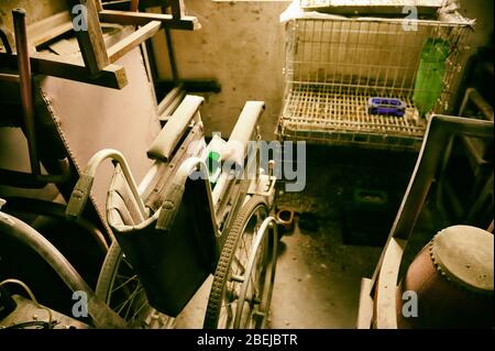 Sporco liberazione con la vecchia sedia a rotelle polverosi abbandonati dal proprietario senior. Foto Stock