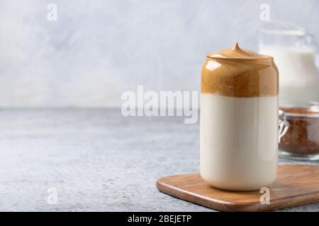 Dalgona caffè in vetro su grigio. Caffè espresso in latte con schiuma di caffè istantaneo. Ha creato una nuova bevanda durante la quarantena e l'autosufficienza Foto Stock