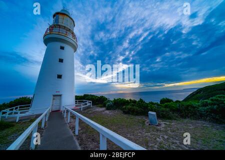 Faro storico di Cape Otway ombreggiato e maledetto sul punto meridionale del cielo drammatico Australiaunder al tramonto nello stato di Victoria. Foto Stock