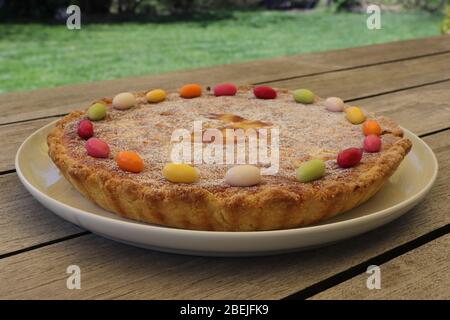 Tradizionale budino di riso torta di Pasqua decorata con uova di zucchero. Vista laterale. Tavolo in legno. Foto Stock