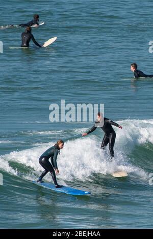 Surfers in azione al Fistral di Newquay in Cornovaglia. Foto Stock