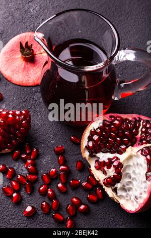 Melograno fresco e succoso, con semi e succo di melograno in una caraffa di vetro Foto Stock