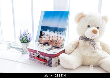 Album fotografico bianco con rivestimento in pelle e legno. Elegante album fotografico per matrimoni. Famiglia photoalbum sul tavolo in legno bianco. Foto Stock