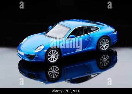Giocattolo blu retro auto girato in studio riflessione. Foto Stock