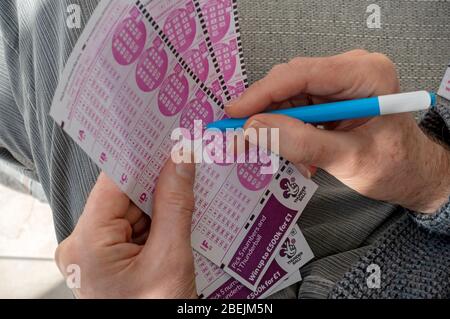 Primo piano di persona uomo mani che tengono in mano compilando il modulo di slittamento della lotteria Thunderball lotto Form Forms Inghilterra Regno Unito GB Gran Bretagna Foto Stock