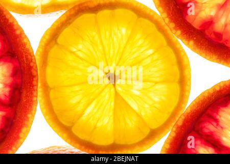 Frutta mista a fette colorate limone e sangue siciliano arancio retro illuminato. Disposizione piatta Foto Stock