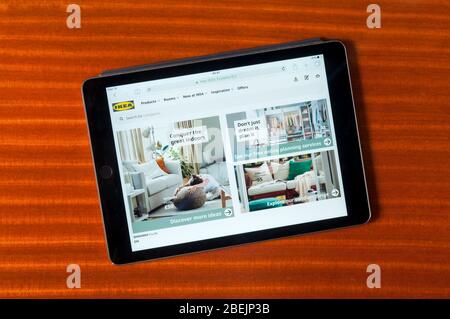 Il sito web dei venditori di mobili IKEA esposto su un iPad tablet computer su uno sfondo di legno lucido. Foto Stock