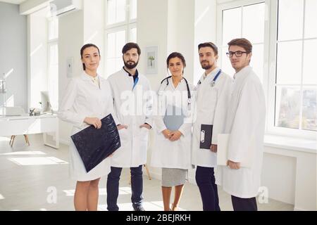 Un team di medici in una riunione discute la diagnosi di un paziente in un ufficio clinico. Foto Stock