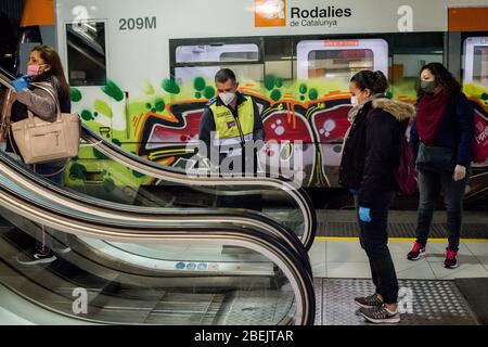 Barcellona, Catalogna, Spagna. 14 aprile 2020 - UNA guardia di sicurezza controlla la distanza tra i pendolari su scale mobili alla stazione Catalunya di Barcellona. Migliaia di persone tornano al lavoro dopo che il governo spagnolo ha revocato le misure più severe di confinamento con il coronavirus. Credit:Jordi Boixareu/Alamy Live News Foto Stock