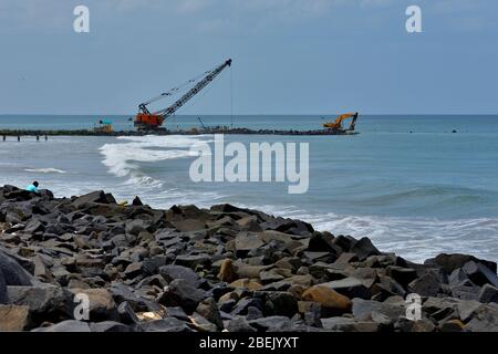 Lavori di costruzione in corso con gru a Rocky Beach a Pondicherry. Foto Stock