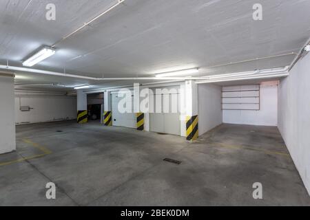 Garage comune per il parcheggio auto in un edificio a più piani con tubi fognari. Foto Stock