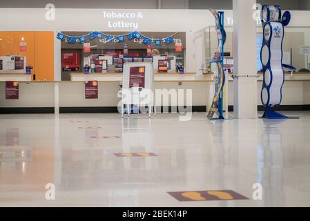 Redhill, Surrey, Regno Unito - 10 aprile 2020 - marcature su un piano supermercato aiutare a mantenere le distanze sociali per fermare la diffusione del coronovirus Foto Stock