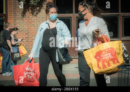 Redhill, Surrey, Regno Unito - 10 aprile 2020 - una donna in maschere protettive andare a fare shopping durante lo scoppio del coronovirus Foto Stock