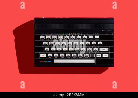 Vecchio computer vintage rilasciato il 1984 con una RAM di 48 Kb su sfondo rosso Foto Stock