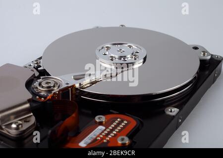 Disco rigido del computer disassemblato con dischi mirror su sfondo bianco, messa a fuoco morbida Foto Stock