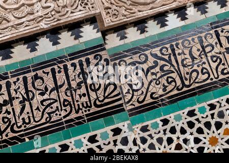 Dettaglio parete con intonaco intagliato e calligrafia coranica verso, Bou Inania Madrasa in Fes. Design tradizionale islamico, tipico delle moschee marocchine e. Foto Stock