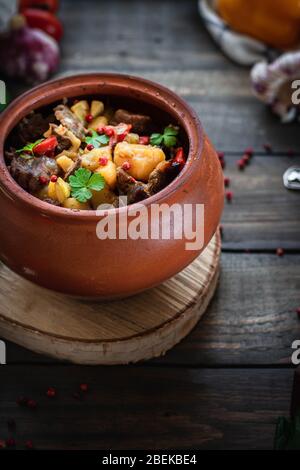 Arrostite in una pentola di argilla in stile rustico. Brasato di manzo con verdure. Piatto georgiano di Canahi Foto Stock