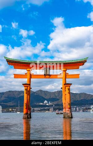 Il gigante rosso arancione galleggiante Grand o-Torii porta si trova nella baia di Miyajima spiaggia a bassa marea di fronte al santuario di Itsukushima in giornata di sole. Hiroshima Foto Stock