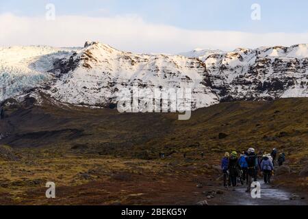 Persona accanto alla laguna di Fjallsarlon iceberg, sotto il ghiacciaio di Fjallsjokull. Parco Nazionale di Vatnajokull, Sudhurland, Islanda Foto Stock