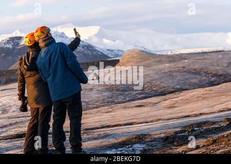 Persona accanto alla laguna di Fjallsarlon iceberg, sotto il ghiacciaio di Fjallsjokull. Parco Nazionale di Vatnajokull, Sudhurland, Islanda Foto Stock