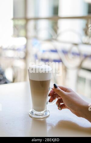 La mano della donna tiene un bicchiere di latte Foto Stock