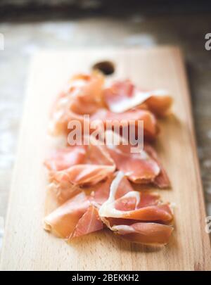 Prosciutto spagnolo su tavola di legno. Tavolo in legno Foto Stock