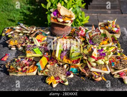 Primo piano orizzontale di scatole fatte a mano riempite di offerte in un tempio a Bali, Indonesia. Foto Stock