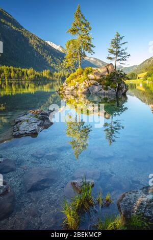 Paesaggio mattutino soleggiato sul Lago Hintersee. Bella scena di alberi su isola rocciosa. Ramsau, Parco Nazionale Berchtesgadener Land, le Alpi, Baviera, Germ Foto Stock